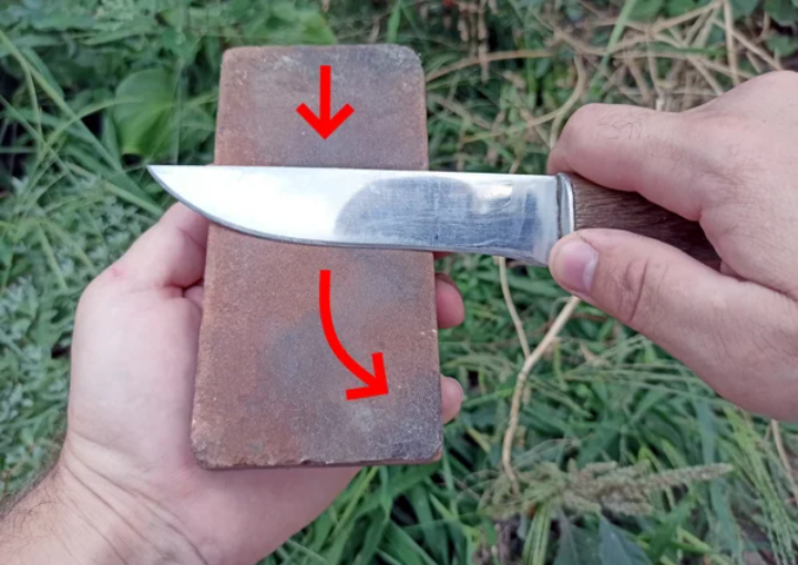 Фото из статьи автора канала "Сделай самоделку" о том как заточить нож. Оселок ущербный, с неровной поверхностью, да и нож, обратите внимание-изношен в середине лезвия