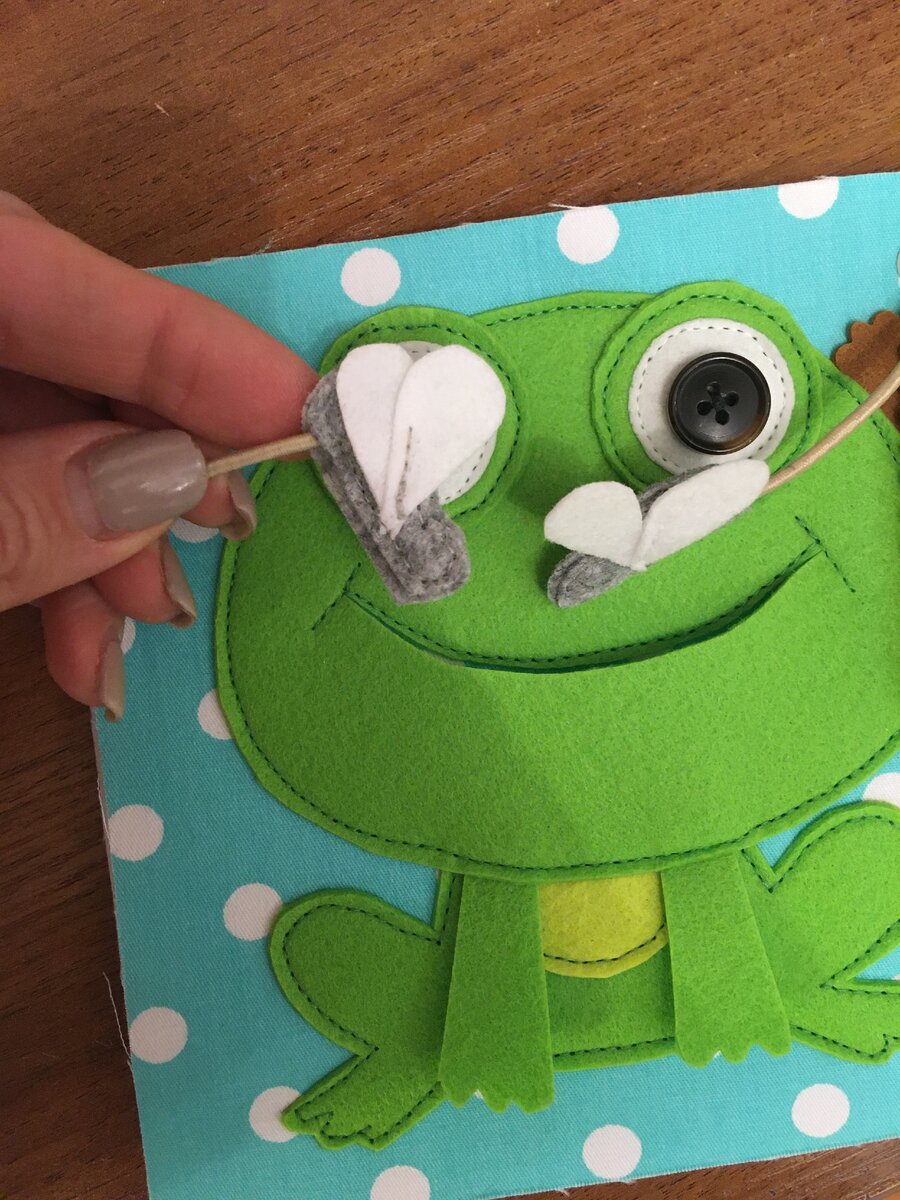 Например,  такая страничка с лягушкой. Мухи - мелкие детали размером 2 х 3 см, соединяются со страницей книги шляпной резинкой. Не достаточно просто всунуть резинку между деталями мухи и проложить шов по периметру. Игла вообще может не попасть в резинку, тогда муха очень быстро слетит с нее, но даже если и попадет, то 1 раз, этот вариант тоже отметаем. Поступить нужно так: на конце резинки завязать узелок, пришить этот узелок к одной из деталей и только потом сложить две детали вместе и проложить шов по периметру, тогда оторвать муху от резинки (без ножниц) будет не реально. То же самое делаем и с другим концом резинки ( у меня он уходит во вторую муху), но может быть и спрятан под лягушкой или обтачкой книги. 