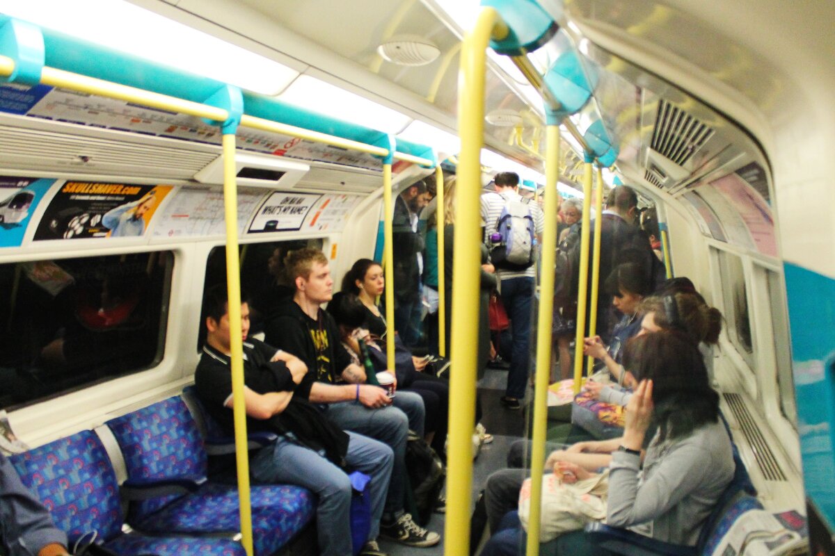 Вот такие тесные вагоны. Если посмотреть на мужчину у двери - видно что ему приходится наклонять голову - неизбежная поза при поездке в Лондонском метро. Даже в центре вагона не так высоко, как в вагонах московского метро.