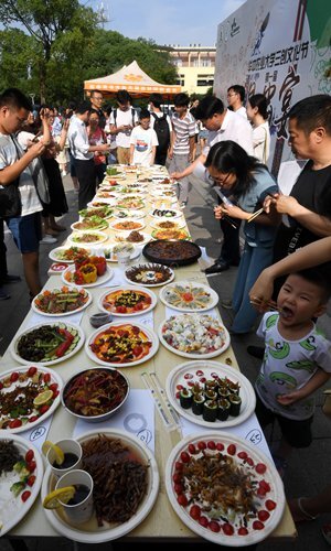 Студенты пробуют блюда из насекомых на специальном банкете для выпускников сельскохозяйственного университета Хуачжун в Ухане, провинция Хубэй, Центральный Китай. Источник: фото VCG