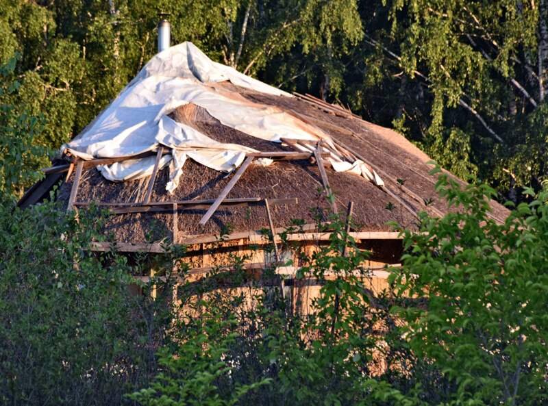 Издалека крыша из соломы, скомканной парусины и хаотично разбросанных палок напоминает купол, однако если внимательно присмотреться то у крыши прослеживается конек. Вид с восточной стороны.