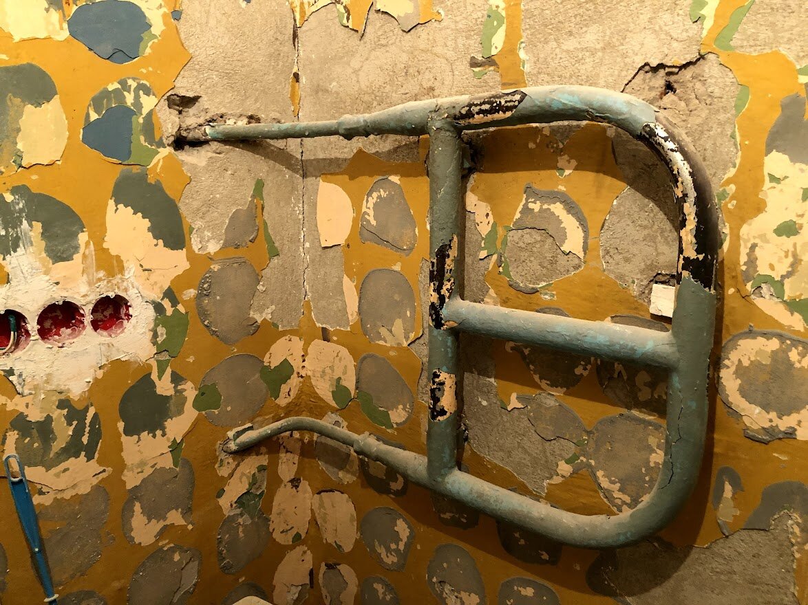 Данная бандура будет вскоре демонтирована и заменена на более аккуратный полотенцесушитель. С левой стороны обнаруживаются вмазанные стаканы новой электропроводки в санитарном узле.