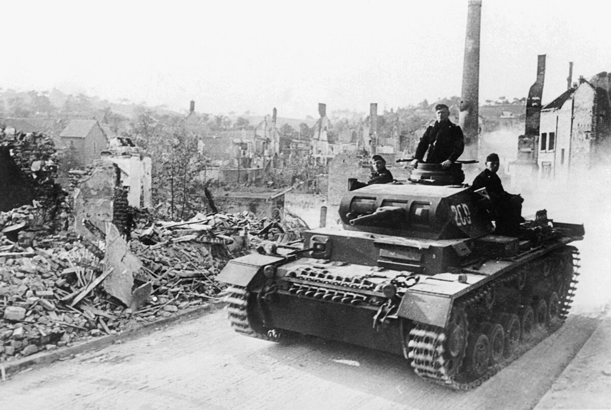 Немецкий танк Pz.III проезжает мимо разрушенной французской деревни