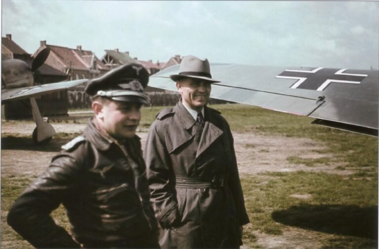  Курт Танк (Kurt Tank, главный конструктор фирмы «Фокке-Вульф») и летчик-ас Йозеф Приллер (Josef Priller, на снимке слева, в военной форме) на летном поле. На фотографии видны самолеты Fw-190
