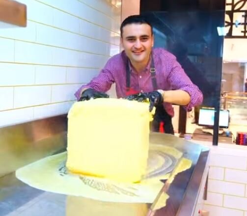 1 — Автор раскатывает гигантский кусок сливочного масла на не менее крупной плите