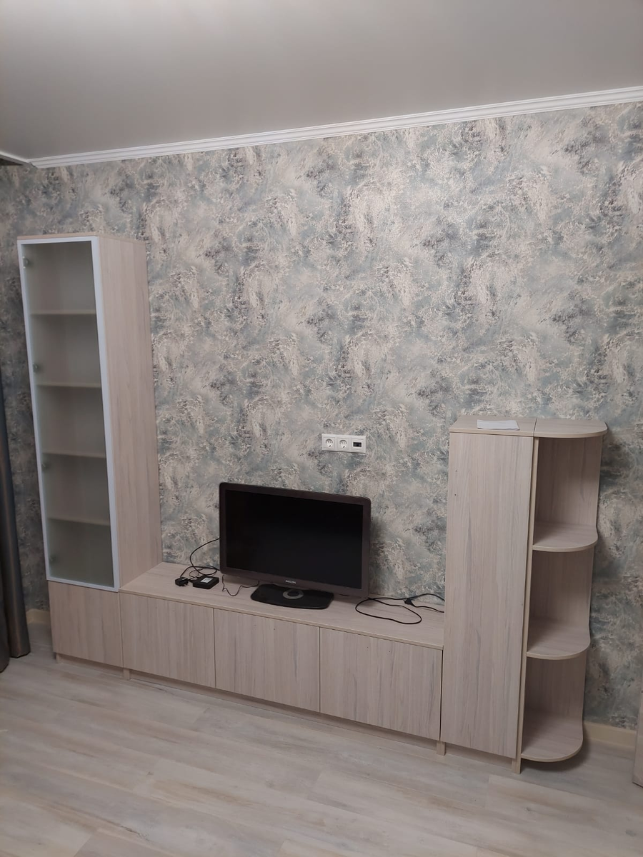 👉Гостиная с ТВ-зоной, большой тумбой и шкафами-колонками, отделанными матовыми фасадами в алюминиевой раме, и открытыми полками