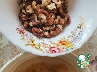     Изюм промыть и залить кипятком на 20 минут. Орехи измельчить.