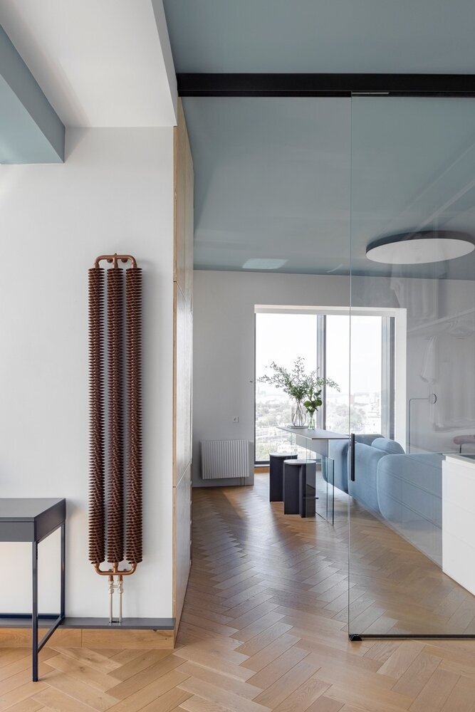 Чтобы выровнять пропорции помещений, часть встроенной мебели спроектировали в форме трапеции. Она маскирует сложный конструктив, сужается и расширяется на отдельных участках, но визуально выглядит ровной.