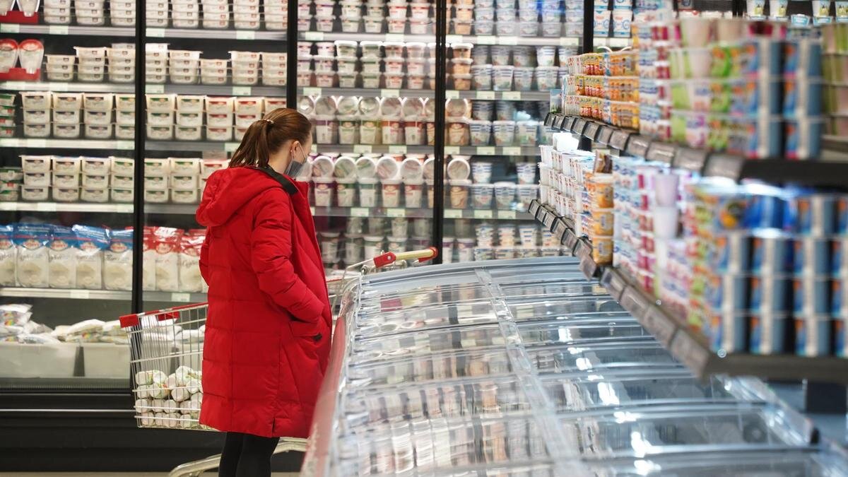    Женщина смотрит на продукты в супермаркете:NUR.KZ / Владимир Третьяков