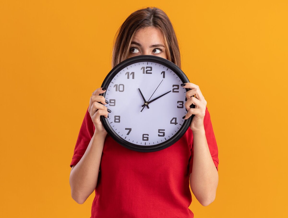 Переход на летнее время 2024. Temprano. Woman looks at Clock at work. 30 Жовтня Україна переходить на зимовий час.