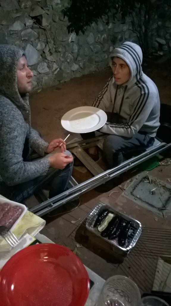 Два друга-"бомжа" готовят баклажаны на углях.