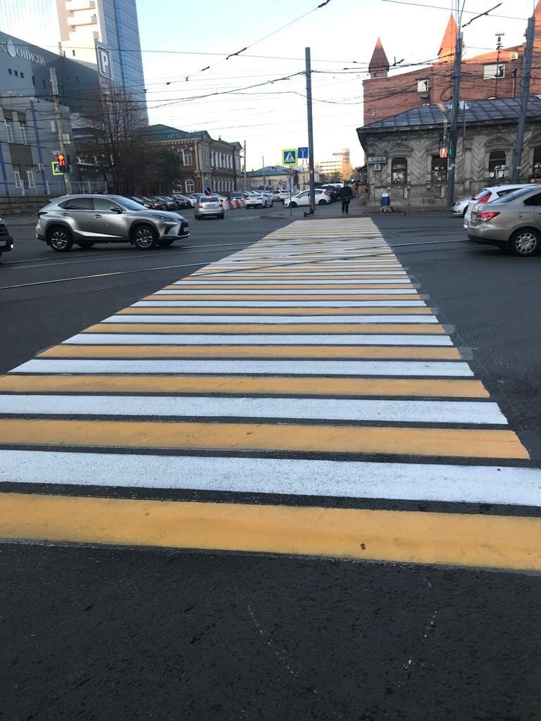 Пешеход около пешеходного перехода, ждёт когда ему уступят дорогу, чтобы перейти.