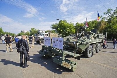    Житель осматривает бронированную инженерную машину M1132 ESV "Stryker" вооруженных сил США ©Мирослав Ротарь РИА Новости