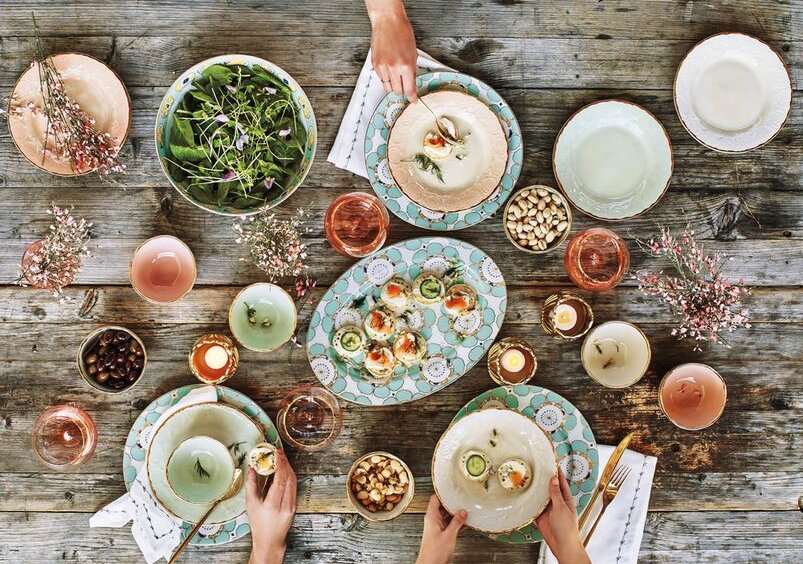 ©www.domino.com 2 серии посуды, одна из которых в нескольких оттенках. Скорее всего это фарфор + керамика = искуссно сделанная работа. Керамическая серия с "потертыми" коричневыми краями - перекликается с необработанным деревом столешницы. Оттенки поддержаны стеклом и цветущими веточками. 