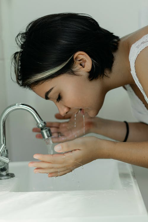 https://www.pexels.com/photo/woman-washing-her-face-with-water-2087954/