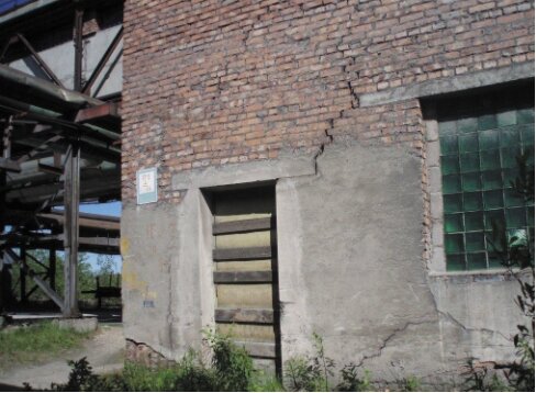 Разрушение отмостки привело к переувлажнению грунта и появлению наклонных трещин в кладке