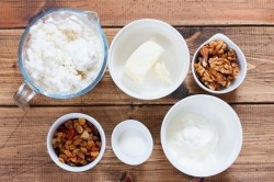 ШАГ 1:
Подготовить указанные ингредиенты. Особое внимание следует уделить творогу: он должен быть свежий, предпочтительней домашний. Жирность лучше брать 9%, но творог не должен быть влажным, выбирайте жирный сухой творог. Также и со сливочным маслом и сметаной - они должны быть свежими. Грецкие орехи и изюм можно заменять и менять количество по своему вкусу. Сахар также можно варьировать в зависимости от предпочтений, можно использовать сразу ванильный сахар.