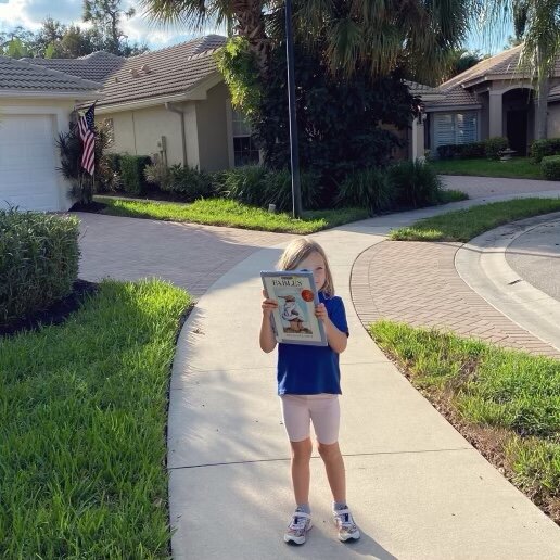 Счастливый ребёнок держит в руках классику американской литературы - Aesop’s Fables