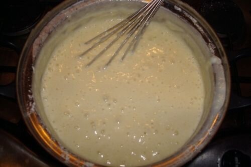     Тщательно смешиваем яйца, сахар, соль и виновника блинного торжества – кефир. Смесь ставим на плиту, не забывая постоянно помешивать ее, и прогреваем до такой степени, чтобы можно было коснуться пальцами рук, но не обжечься. Далее потихонечку всыпаем муку и мешаем, я делаю это при помощи миксера. Соду нужно развести в стакане кипятка, обратите внимание не холодной или теплой воды, а именно воды, только что доведенной до кипячения. Воду быстро вливаем в смесь и вымешиваем. Готовое тесто для блинов ставим в сторону от себя и даем ему отдохнуть в течение получаса.   