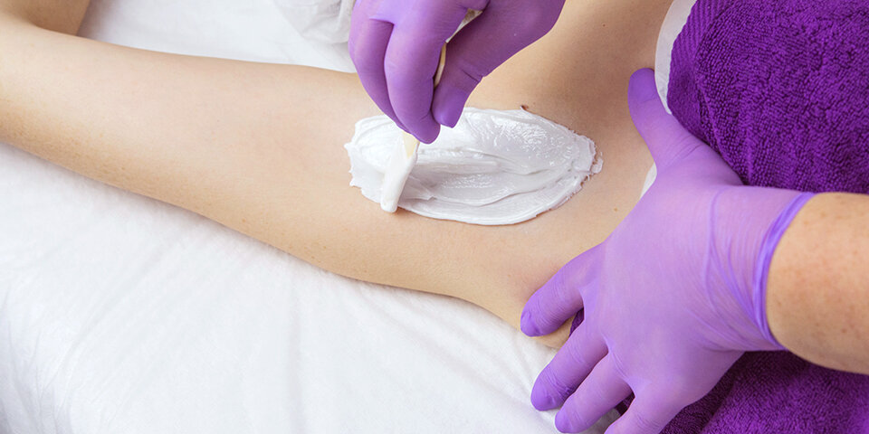 Мастер депиляции удаляет волосы полимерным воском ARAVIA Professional VANILLA-DELICATE, разработанном для депиляции деликатных и чувствительных зон