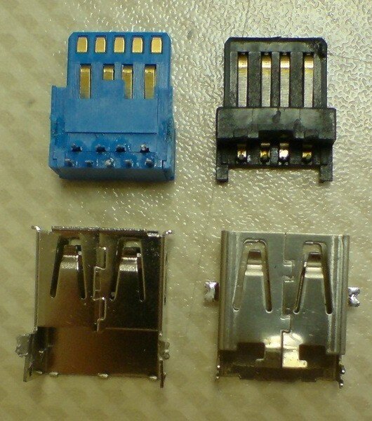 Сравнение разъемов USB 3.0 и 2.0 
Частота, в свою очередь, не может наращиваться бесконечно. Во-первых, сигналы должны быть достаточно мощными, чтобы не затухать от сопротивления провода и разъемов. Если не наращивать мощность сигнала – нужно наращивать чувствительность приема, что делает оборудование более уязвимым к влиянию помех.

Увеличить скорость, и вместе с тем сохранить устойчивость к шуму, можно путем увеличения числа жил. Это в итоге и было сделано при переходе с USB 2.0 до 3.0 (жил в кабеле стало 9, вместо 4). Но и эта возможность не безгранична, когда-то (причем, относительно скоро) последующее усиление линий связи сделает невозможным или непрактичным существование USB в современном виде.

Трудность масштабирования
При нехватке пропускной способности одной линии – ее можно компенсировать использованием нескольких каналов параллельно. Если приводить наглядный пример, то это выглядит как добавление новых полос по бокам трассы, которая не справляется с потоком транспорта. Вдвое больше полос – вдвое больше машин.

Такое масштабирование широко используется в электронике. Протокол PCI-Express хоть и является последовательным, но поддерживает масштабирование путем увеличения числа линий. Но, сравнив разъемы PCI-E x1 (1 линия) и x16 (16 линий) можно понять, почему для USB, ориентированного на быстрое подключение оборудования, такой вариант не подходит.