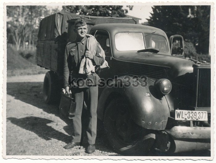 Немецкий солдат у грузовика «Ford V-8»,снабженного газогенераторной установкой для использования в качестве топлива дров,угля или торфа.