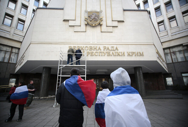 Демонтаж украинской надписи на здании Верховной рады Крыма. Фото: Reuters