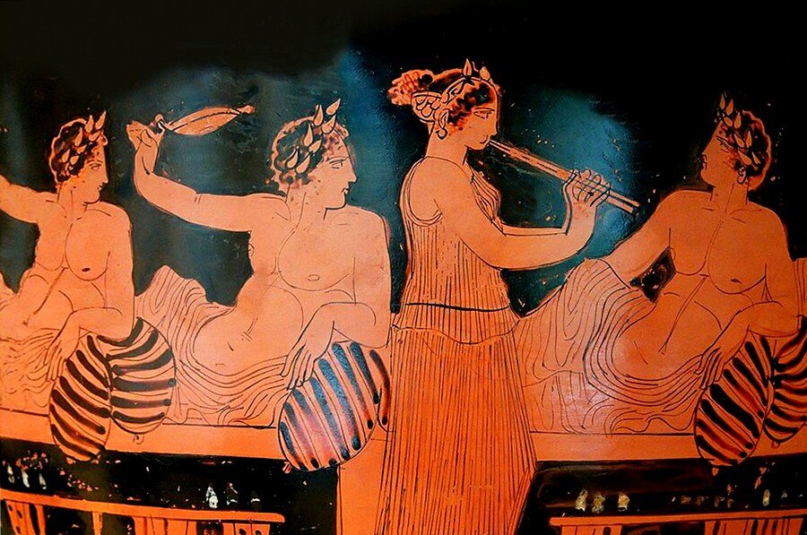 Игрок в коттаб наблюдает за девушкой играющей на флейте.