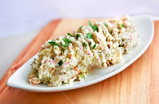 Готовый картофельный салат красиво сервированный.