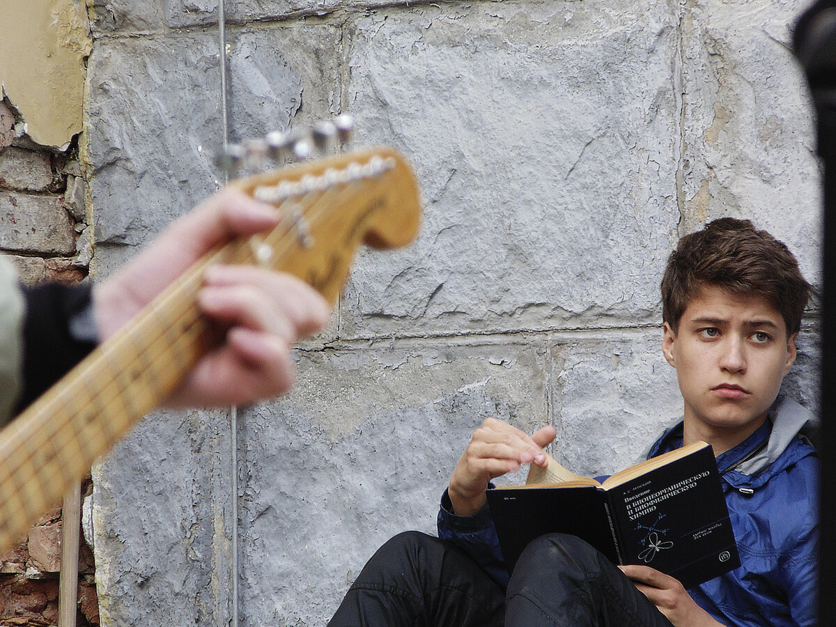 Фотка с уличного концерта в Екатеринбурге. Парень сидел прямо у сцены и читал про квантовую физику.