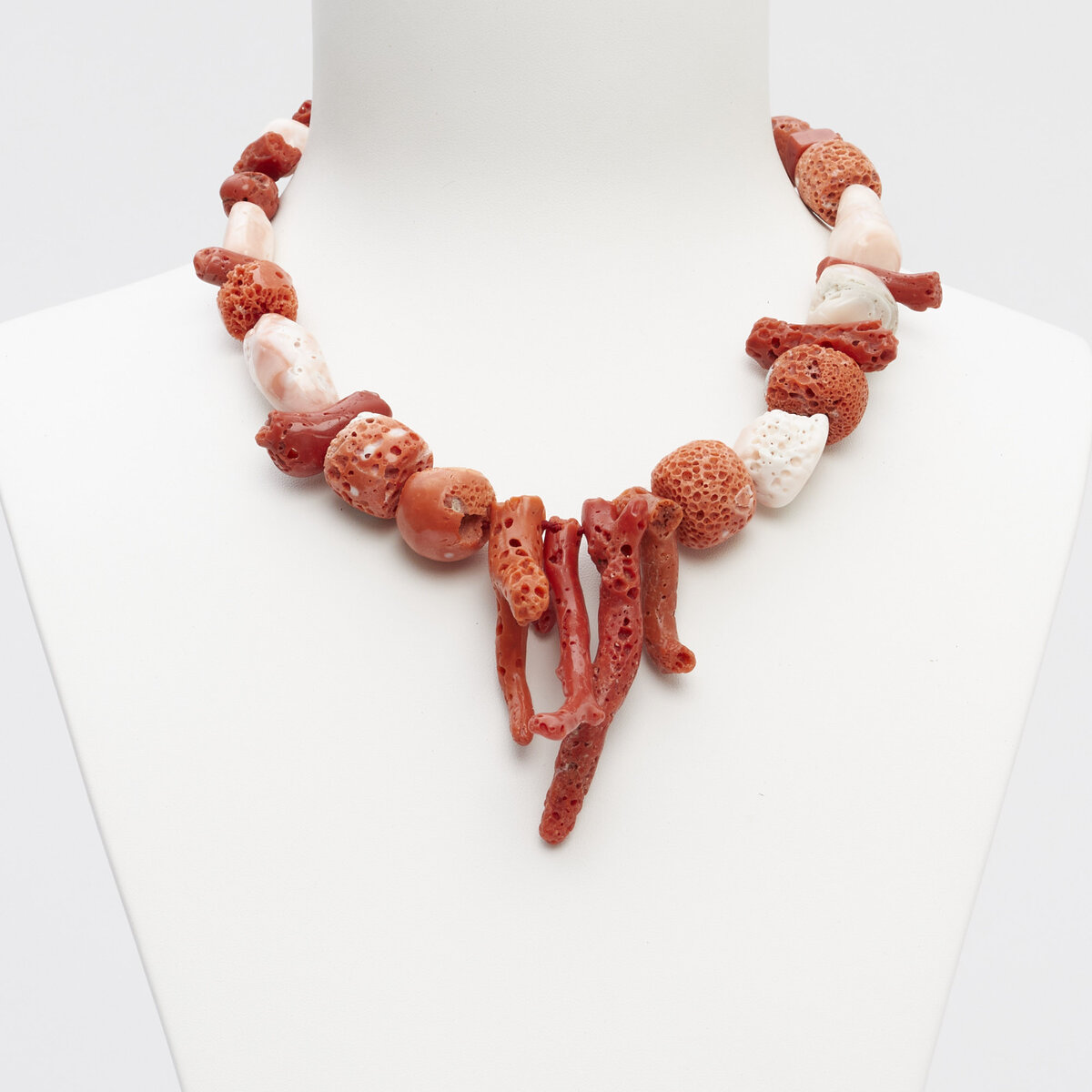 Ожерелье из необработанного коралла красного и светло-розового цвета.