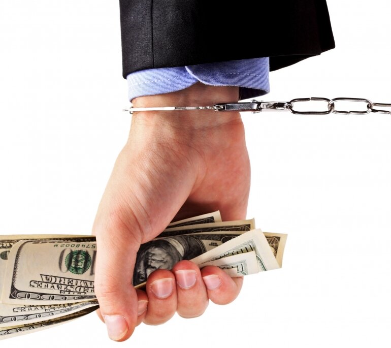 Деньги в руке в наручниках