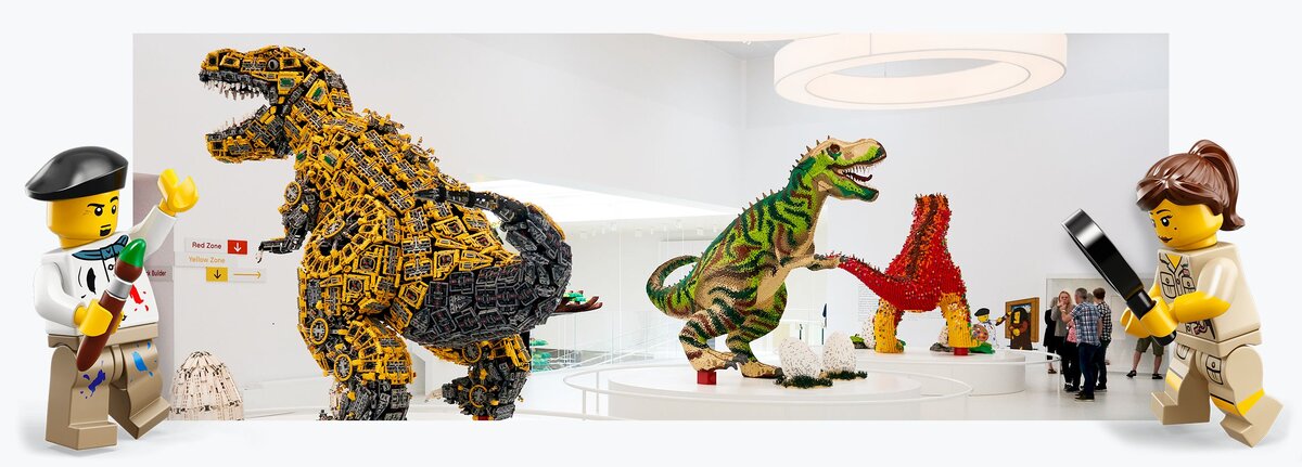 Три гигантских динозавра из LEGO приветствуют посетителей, когда они поднимаются по лестнице в галерею LEGO House 