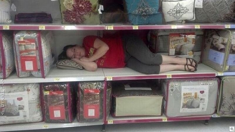 Продавец лежит на прилавке. Уснул в магазине.