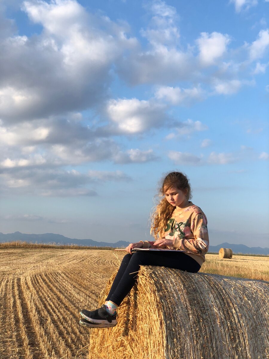  Учиться можно не только за партой. Полина в поле с книгой.