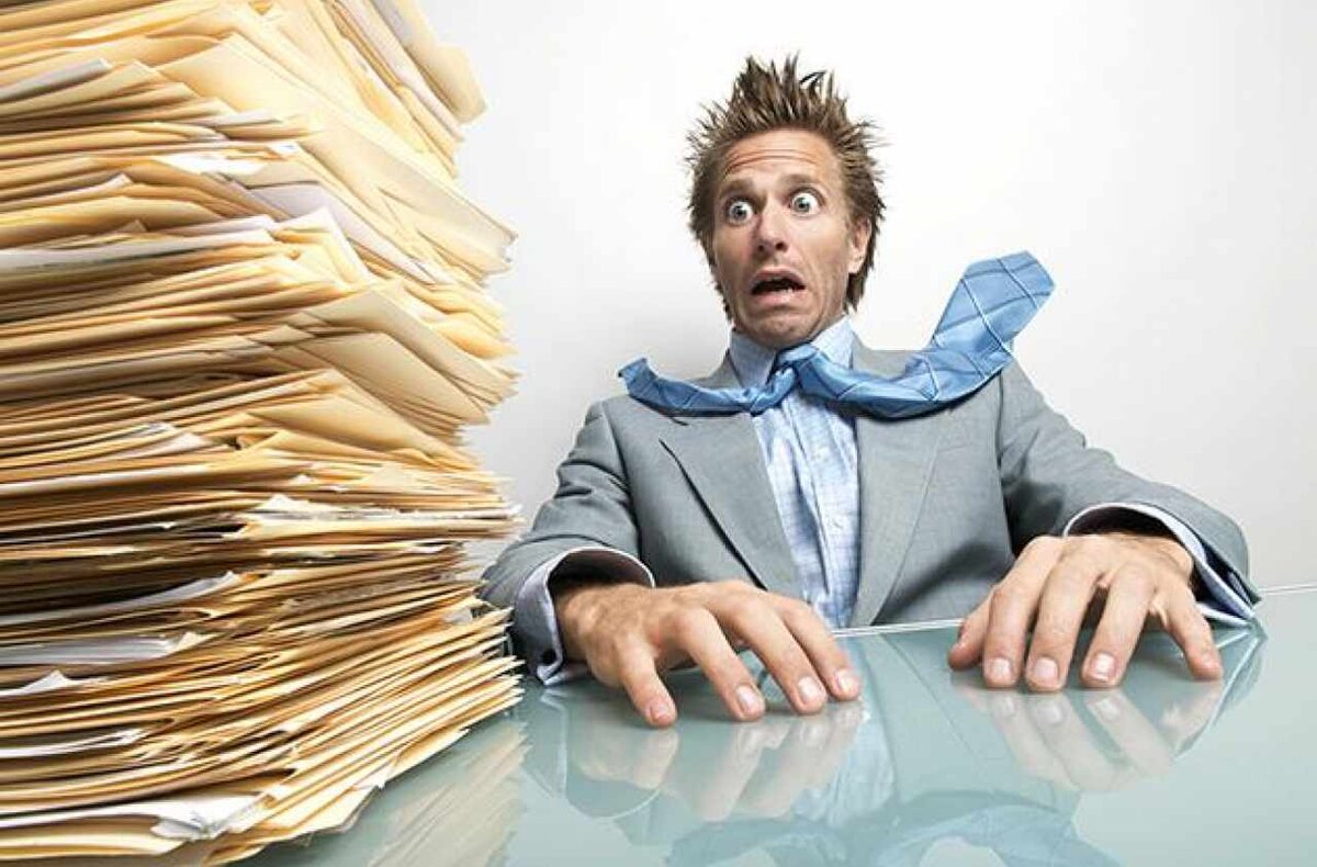 Устал разобрать. Человек с кучей бумаг. Много документов. Человек и много документов. Человек на работе много бумаг.
