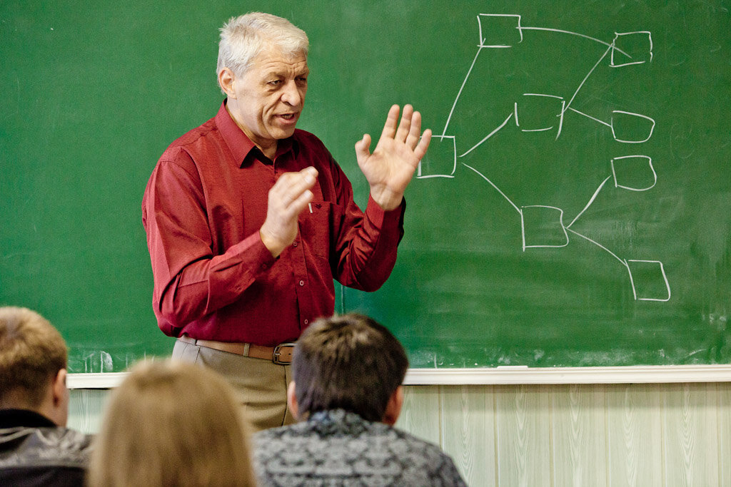 Большим вниманием. Преподавание в вузе. Учитель в аудитории. Преподаватель вуза. Преподаватель на лекции.