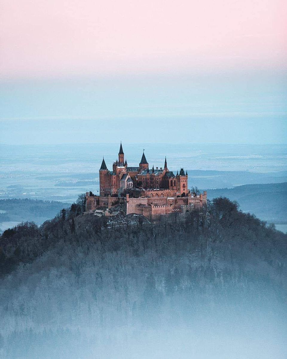 Высоко-высоко в горах, над облаками... Замок Гогенцоллерн.  Замок Гогенцоллерн (нем. Burg Hohenzollern) — старинный замок-крепость в Баден-Вюртембергев 50 км южнее Штутгарта. Вотчина Гогенцоллернов — династии, возвысившейся на протяжении Средневековья и правившей в Пруссии и Бранденбурге до конца Первой мировой войны. Замок расположен на вершине горы Гогенцоллерн на высоте 855 метров и находится недалеко от населенных пунктов Хехинген и Бизинген.  Первый замок  Первая средневековая замковая крепость дома Гогенцоллернов впервые упоминается в 1267, однако предполагается, что она была построена ранее, в XI веке. В 1423 крепость была осаждена войсками имперских городов Швабии. 15 мая 1423 года, крепость была взята и полностью разрушена. От первого замка сохранились лишь письменные упоминания.  Второй замок  В 1454—1461 годах был возведен второй замок. Во время тридцатилетней войны (1618—1648) замковая крепость имела важное стратегическое значение. И в 1634 замок был захвачен войсками Вюртемберга. После окончания тридцатилетней войны замок продолжает находиться под габсбургским контролем. Во время войны за австрийское наследство (1740—1748) замок был оккупирован французскими солдатами на протяжении зимы 1744-1745 годов. После этой войны крепость, как стратегический объект, теряет своё значение и постепенно приходит в запустение. Когда в 1798 году последний австрийский владелец замка покидает его, комплекс строений начинает стремительно разрушаться. К началу XIX века замок был уже в руинах и лишь часовня св. Михаила продолжала использоваться.  Третий замок  Замок был отстроен при содействии кронпринца (впоследствии короля) Фридриха Вильгельма IV. Строения, которые существуют в наше время, возводились под руководством известного берлинского архитектора Фридриха Августа Штюлера, который в 1842 году будучи ещё студентом и учеником Карла Фридриха Шинкеля был назначен на должность королевского архитектора.   Замок выстроен в неоготическом стиле, под сильным влиянием движения немецкого романтизма воспевавшего средневековую идиллию.   Замок Гогенцоллерн — это воплощение утопического средневекового рыцарского замка: такого, каким он должен был бы быть. В этом отношении он близок к замку Нойшванштайн в Баварии, хотя и без фантастических элементов декора. Восстановленный родовой замок служил в основном для укрепления престижа правящей прусской династии Гогенцоллернов.  Возведение замка было начато в 1850 году и полностью завершено 3 октября 1867 года при германском императоре Вильгельме I. Замок был поврежден землетрясением 3 сентября 1978 года и до середины 1990-х годов был закрыт для посещения на реконструкцию. 