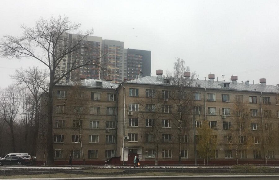 За проблемными пятиэтажками высится здание, куда обещали переселить жильцов бывших общежитий.