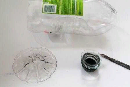 Отрежьте ножом у бутылки горлышко и дно, чтобы она стала открыта с обеих сторон, но края остались закругленными. Если будущий абажур длинноват, то укоротите его: вырежьте кусок из середины, а затем клеевым пистолетом или степлером «пристрелите» обе части вместе.