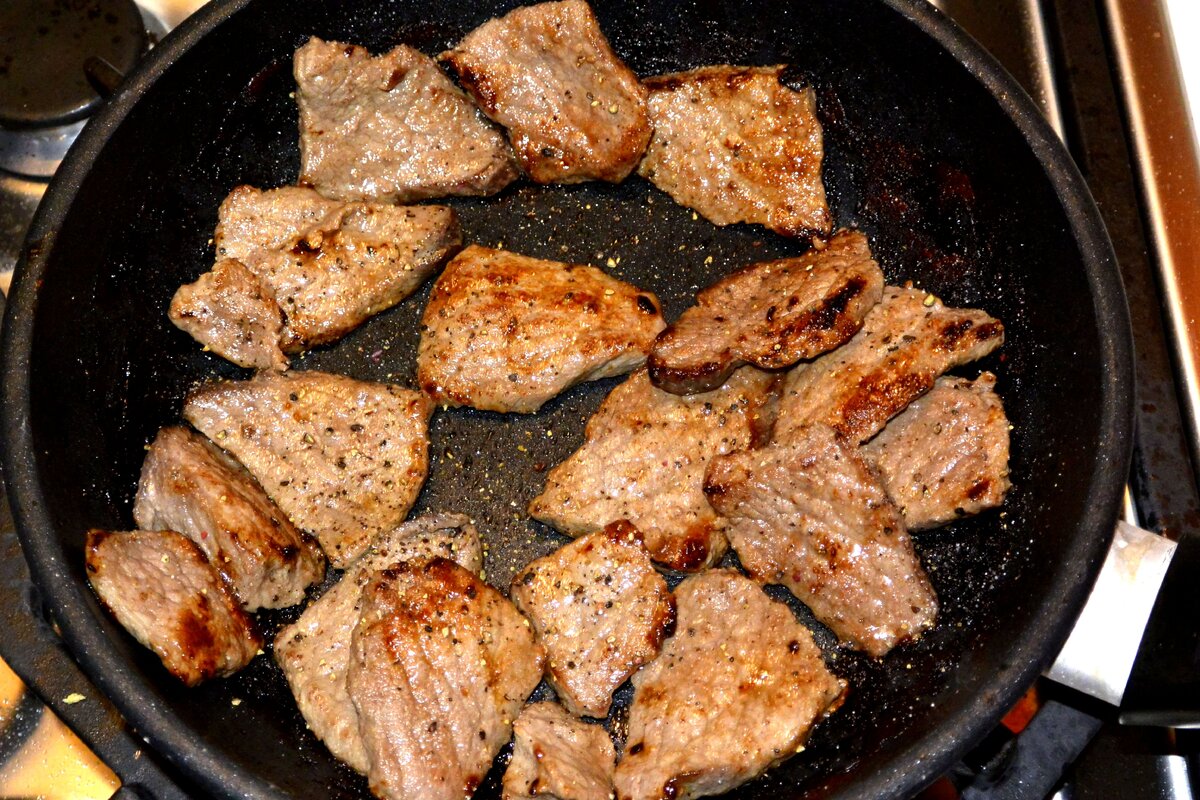 Мясо нарезаем небольшими кусками, толщиной 6-8 мм., и обжариваем в хорошо разогретой сковороде с маслом, на сильном огне. Как только сок мяса выпарится, который она дала при жарке, обжариваем его еще не более 2 минут и затем, снимаем мясо с плиты. 