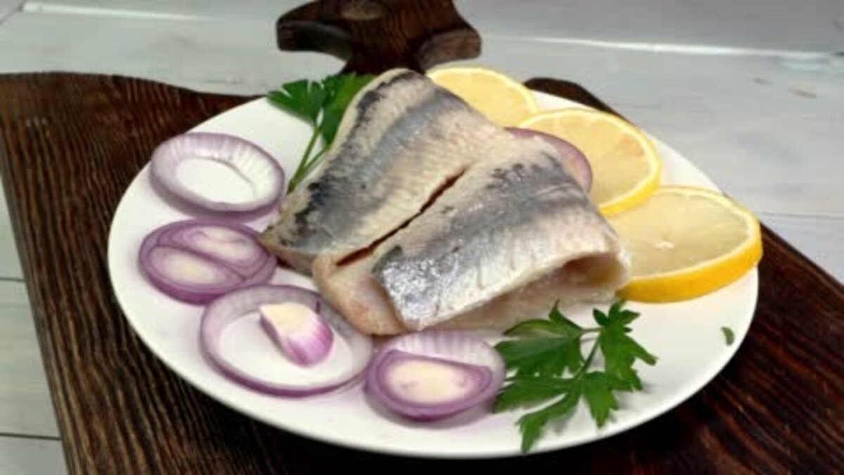 Вкусное рыбное филе из соленой сельди с кольцами лука, лимоном и зеленью петрушки. Фото автора: UncleDmytro 