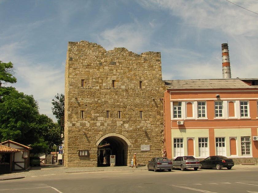 Крепостные ворота (Одун базар-капу)
В далекие времена, эти ворота, были въездом и выездом из города. От них велся путь до Симферополя и Бахчисарая. Исторический возраст ворот более пятисот лет. Но, к сожалению, в 1959 году, ворота разрушили, но к юбилею 2500 лет города, в 2004 году, ворота восстановили в их былой величине и красоте. Поэтому можно легко представить, как в них въезжали татарские князья и ханы, казаки и турки. Крепостные ворота, еще называют Гизлевскими, в нутрии расположен частный музей, снаружи к воротам прилегает кафе.