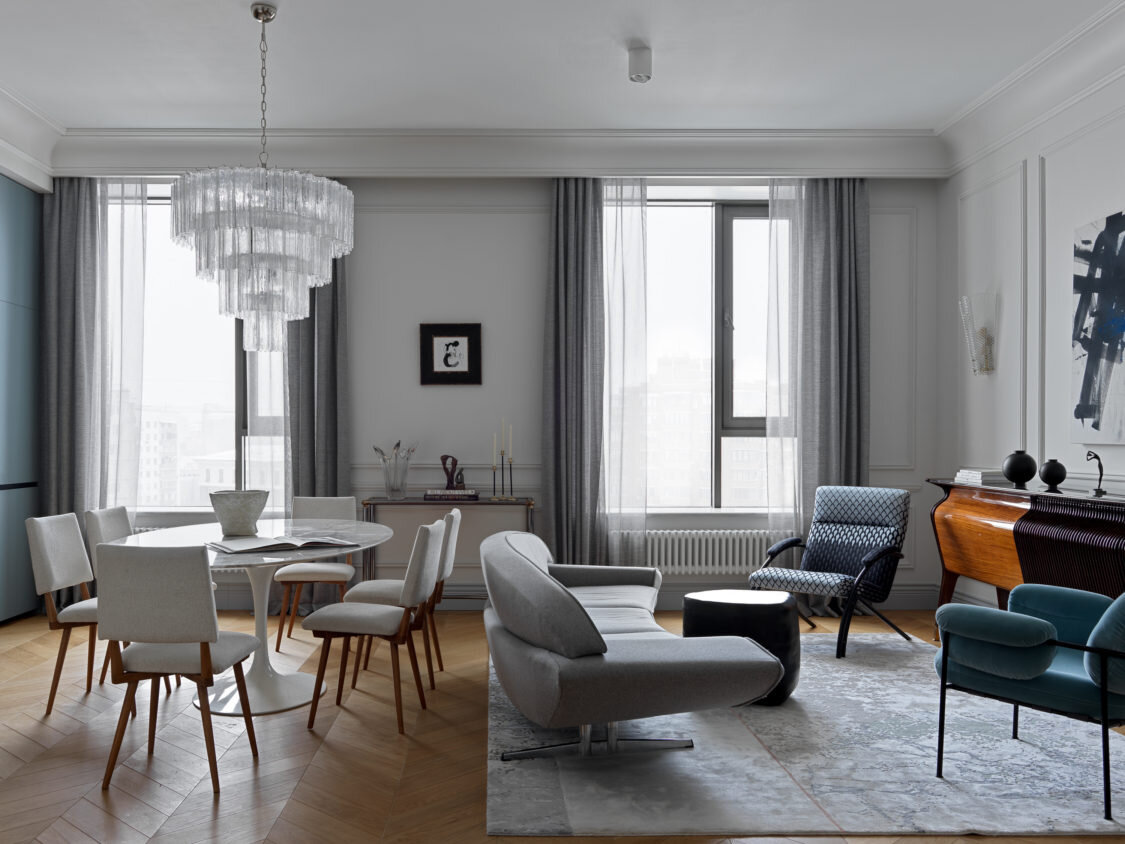  Гостиная-кухня. Обеденный стол, Knoll; стулья винтажные, из мастерской Stoolstory; люстра, Vеnini, и диван, Johansson Anderson, куплены в Gallery Beke; комод, Osvaldo Borsani, 1950-е годы, и кресло куплены в Repeat Story; ваза и керамический столик — в галерее Savour; декор на комоде и голубое кресло, L’appartement; картина в простенке, галерея Carré d’artistes.