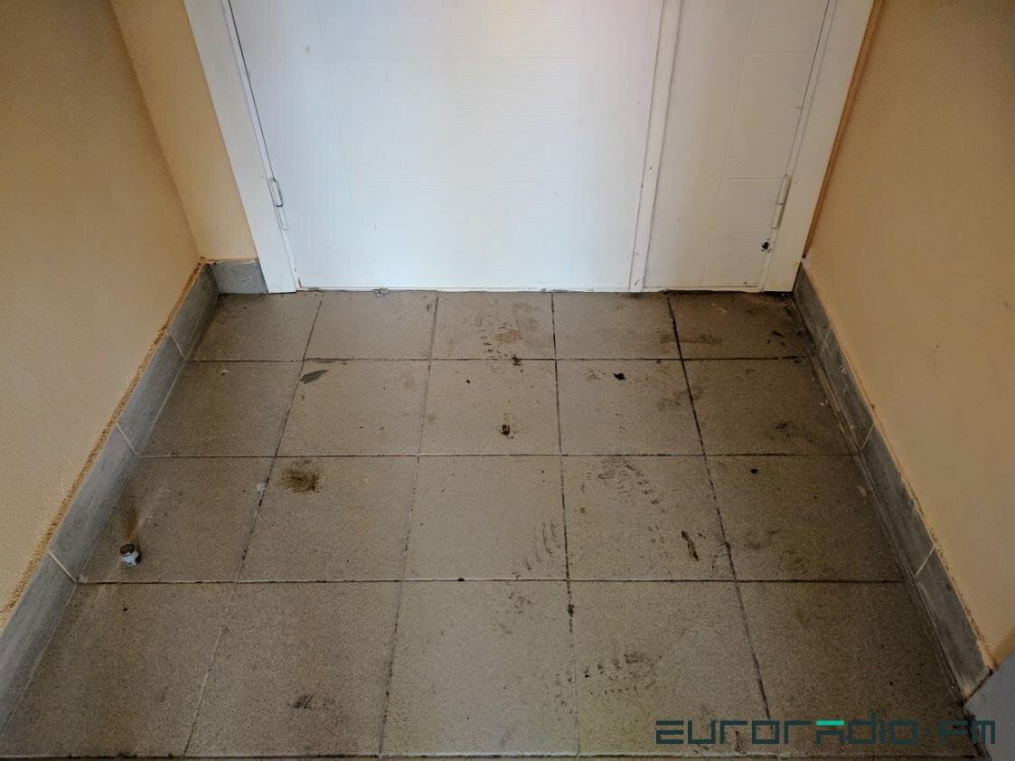 У двери, за которыми находится общий на 4 квартиры коридор, на грязи видны следы и пятна крови.