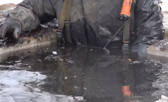 Поисковик аккуратно погружается в студеную воду, чтобы начать тралить подледное пространство магнитом. 