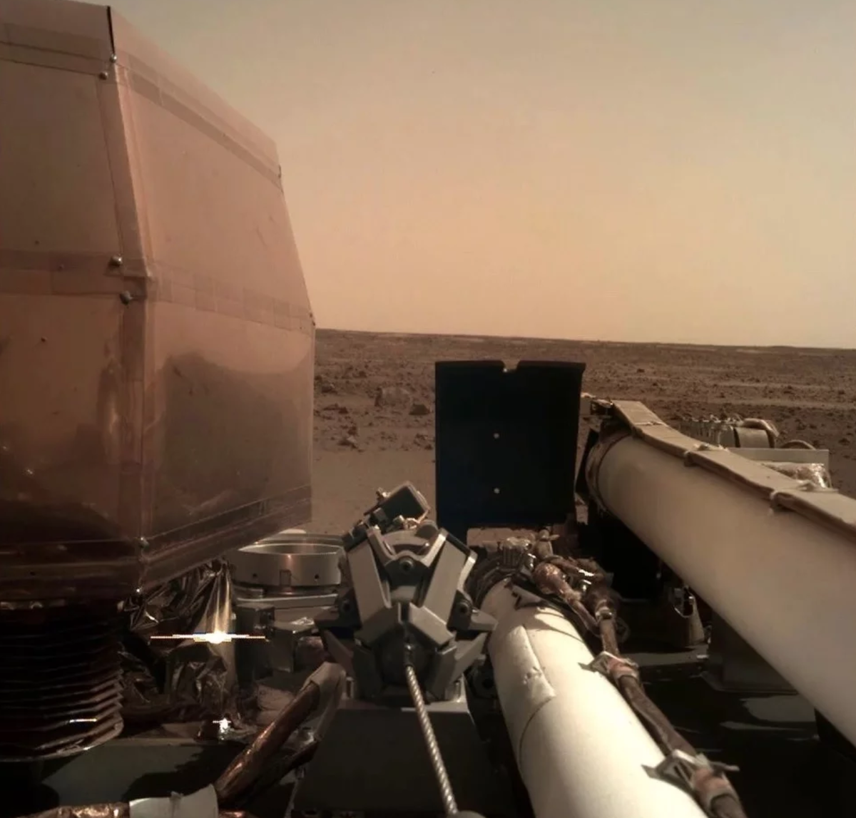 Фотография марсианской пустыни, полученная с камеры модуля InSight 26 ноября 2018, вскоре после прибытия на Красную планету. Снимок подлинный, никакого монтажа и дополнительных эффектов.