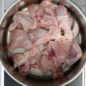 1.  Разрезать курицу на небольшие кусочки (по 3–4 на порцию), сложить в кастрюлю или глубокую сковороду, предварительно налить растительное масло, и поставить тушить под закрытой крышкой.