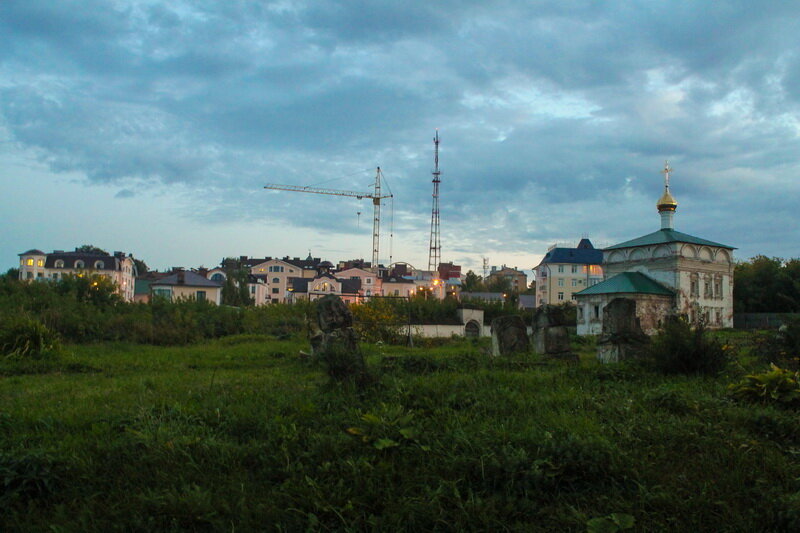 Взгляд с территории Успенского Трифонова монастыря на элитные новостройки. На первом плане - видны надгробия старинных захоронений.