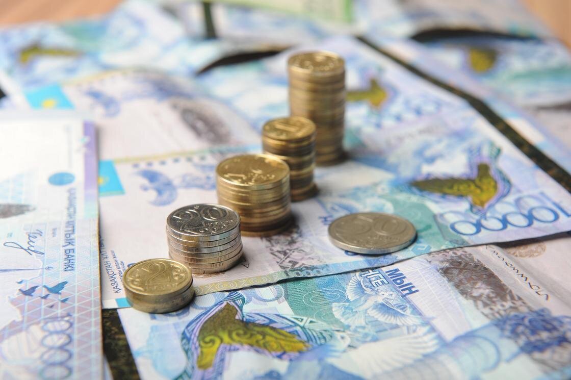    стопки монет стоят на купюрах тенге:NUR.KZ/Владимир Третьяков